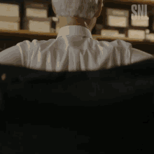 a man 's back is shown with a snl logo in the background