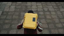 a person holding a yellow box with a sticker on it that says ' ambulance ' on it
