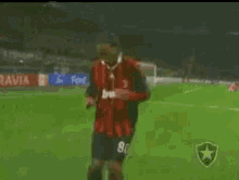 a soccer player wearing a red jersey with the number 8 on it is running on the field .
