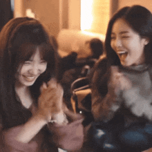two women are sitting next to each other and smiling