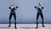 a woman in a black and white superhero costume stands with her arms in the air