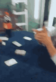 a blurry picture of a person playing a game of cards on a table .