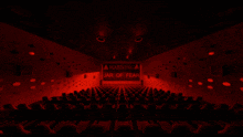 an empty movie theater with a warning sign on the screen