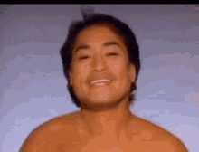 a shirtless man is smiling with his eyes closed .