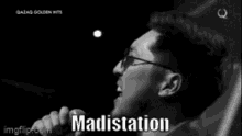 a black and white photo of a man singing into a microphone with the word madistation written below him