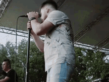 a man is singing into a microphone on a stage