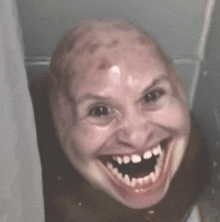 a close up of a person 's face with a huge smile on their face .