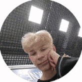 a young man is taking a selfie with his hand on his face