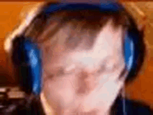 a man wearing headphones with a microphone on his head is looking at the camera .