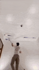 a man is working on a ceiling with a drill