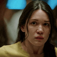 a close up of a woman 's face with a yellow shirt