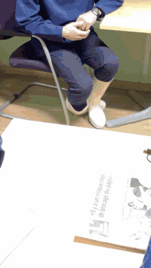 a person wearing white boots sits on a chair next to a sign that says " only a few people need to know "