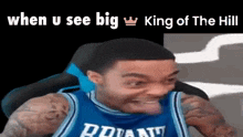 a basketball player in a blue jersey is making a funny face while sitting in a chair .