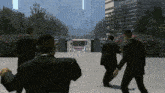 a group of men in suits are walking down a street in front of tall buildings