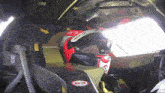 a man wearing a red orlen helmet sits in the driver 's seat of a race car
