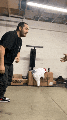 a man in a black shirt is standing in front of a rogue box