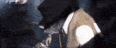 a man in a hat and vest is talking to another man in a dark room
