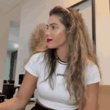 a woman wearing a white shirt that says hundred