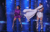 a woman in a purple dress is dancing with a woman in a white dress