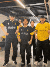 a group of young men wearing black and yellow shirts with nubia on them