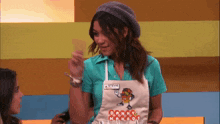 a woman wearing an apron that says danny mangoes on it