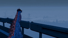 a blue dinosaur wearing a hat looks out over a city