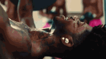a man with a tattoo on his neck is laying down with his head on a table .