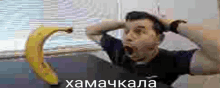 a man is laying on a bed with a banana in his mouth .