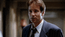 a man wearing a suit and tie looks at the camera