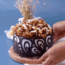 a person is decorating a cake with popcorn on top