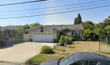 a car is parked in front of a house with a garage