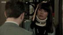 a woman with a neck brace is talking to a man with bbc written on the bottom of the screen