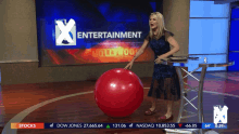 a woman stands in front of a screen that says entertainment hollywood