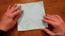 a person is folding a piece of paper with the words made in animotica visible