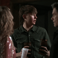 a man in a green shirt is talking to a woman in a pink dress