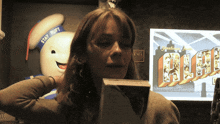 a woman holding a book in front of a screen that says ahhh