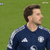 a man wearing a blue shirt with the word united on it