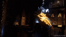 a gif from gifrun.com shows a statue in a dark room with flames coming out of it