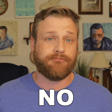 a man with a beard wearing a blue shirt with the word no on it