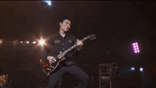 a man playing a guitar on a stage with the letter d visible in the corner