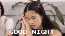 a woman is sleeping with her head on her hands and the words `` good night '' written on the screen .