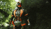 a man in a superhero costume is holding a sword and a light coming out of his belt .