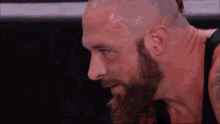 a man with a beard and a bald head is standing in a ring .