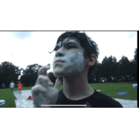 a man with foam on his face is standing in the grass