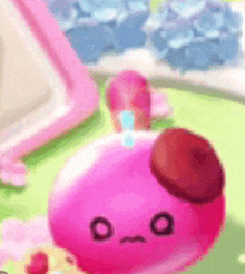 a close up of a pink object with a face on it