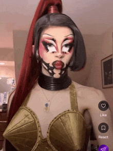 a woman wearing a gold bra and a black choker has a like and react button on her screen