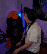 a woman wearing headphones is sitting in front of a stuffed animal that says just one more game