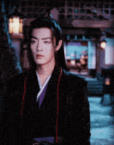 a man wearing a black jacket and a purple kimono