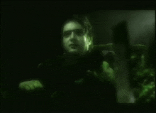 a blurry picture of a man 's face is displayed in a dark room
