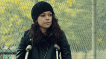 a woman with crutches is wearing a black beanie